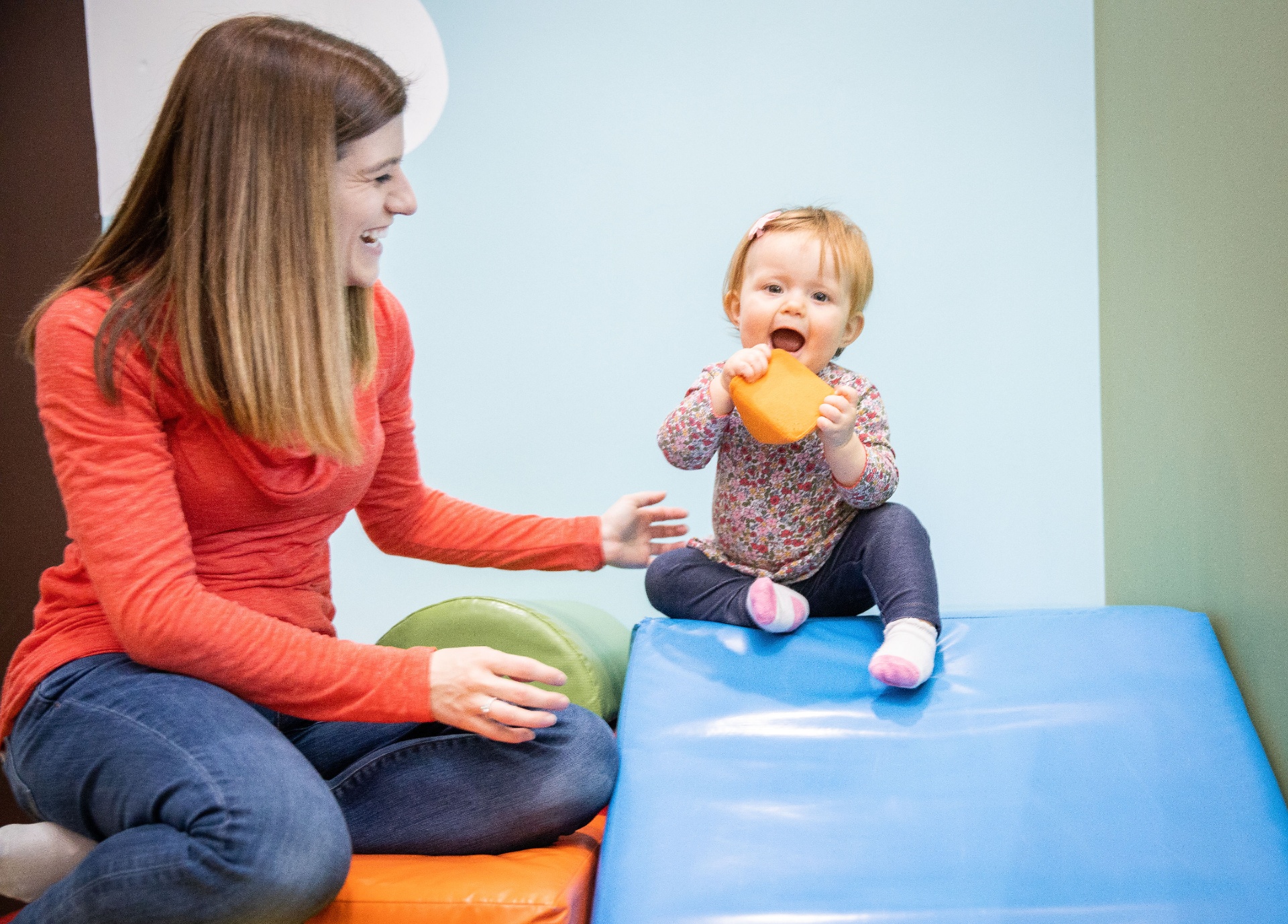 Therapist laughing with a baby during a play-based therapy session