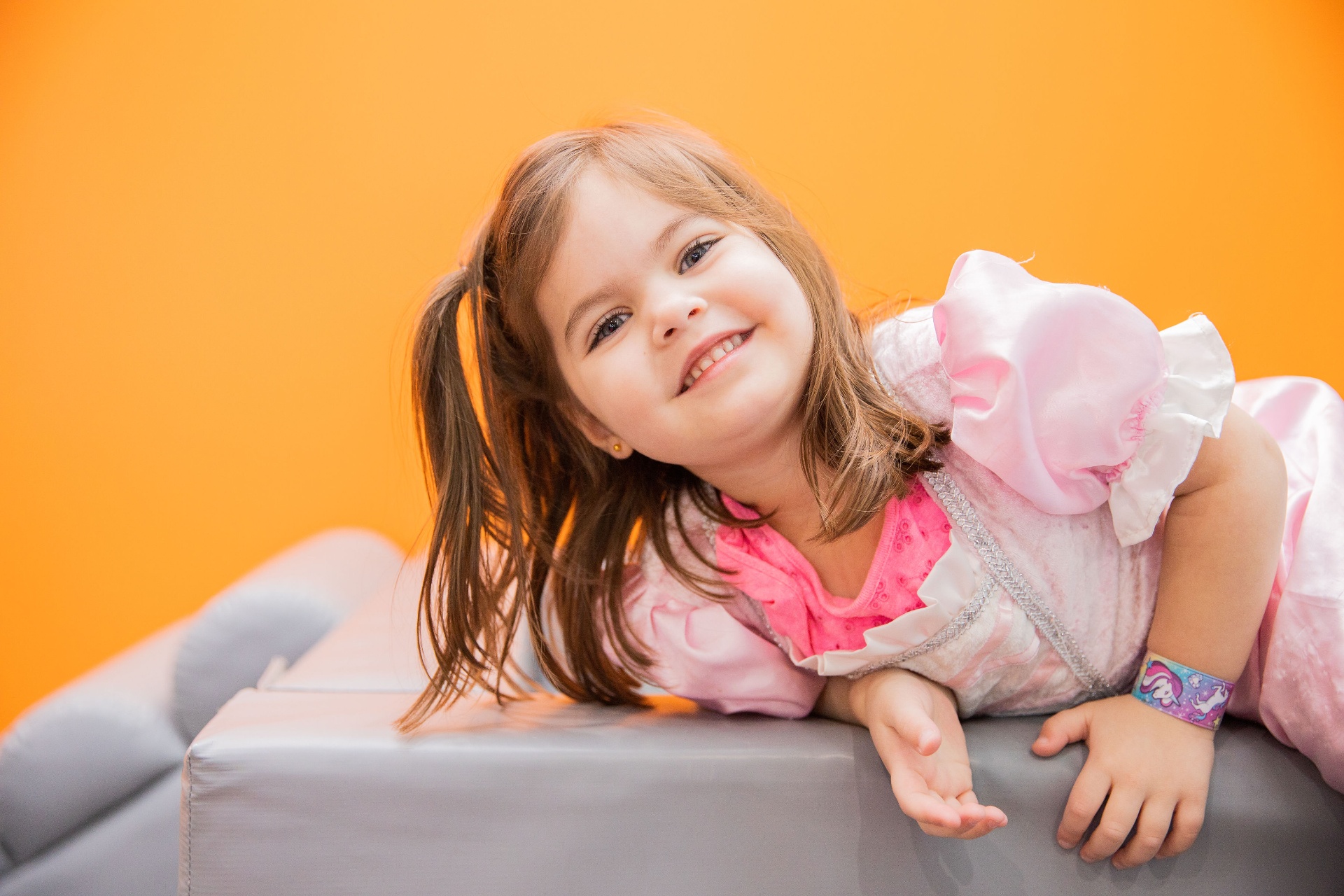 Happy preschooler in a princess dress on a soft climber