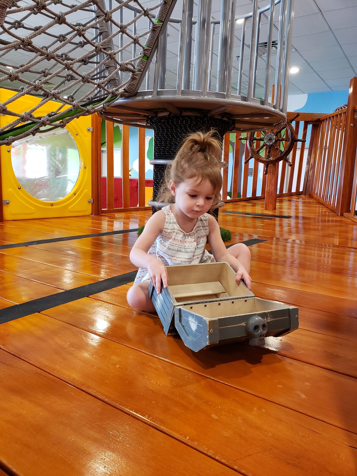 Wide view of the Little Land Waco play gym with pirate ship climber, ball pit, and platform swing