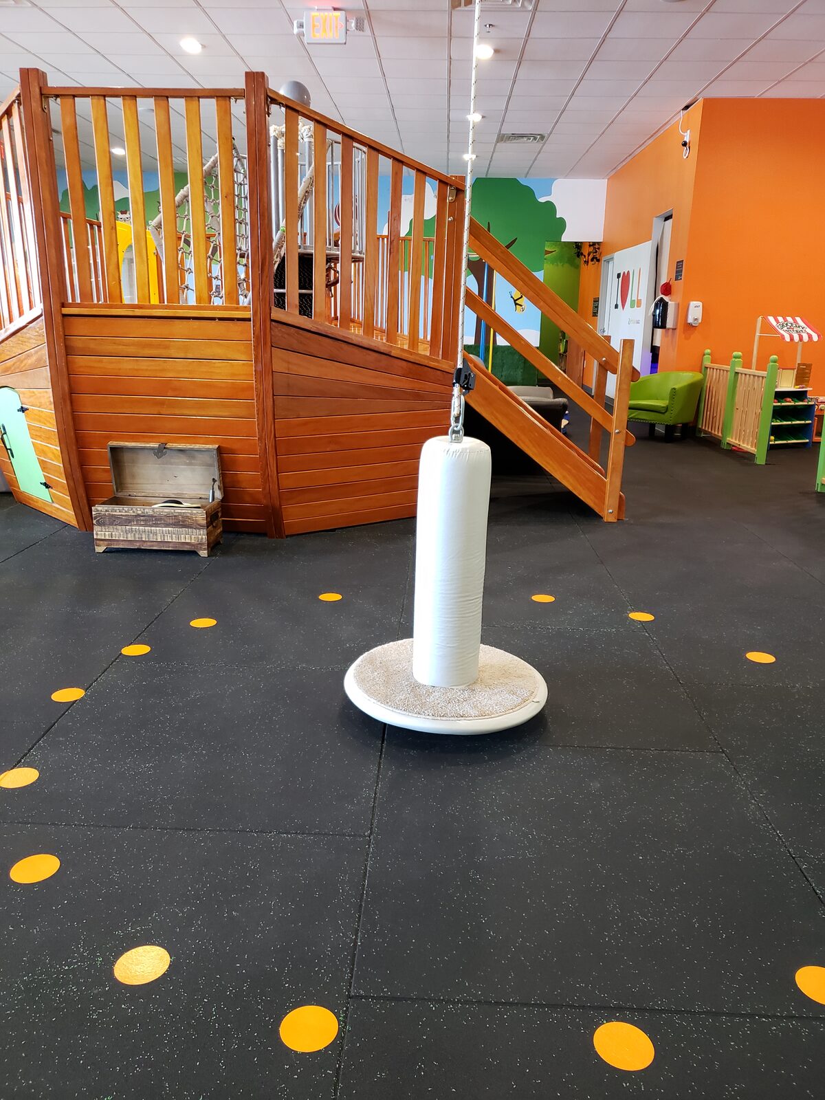Wooden pirate ship climber and punching bag swing on the gym floor
